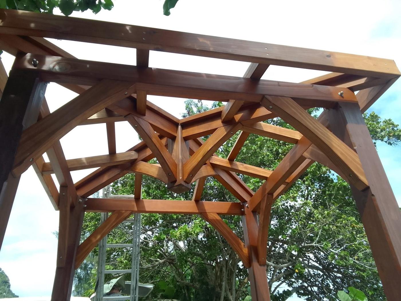 Kiosque en charpente bois assemblée, vu de dessous : poteaux, arbalétriers et entretoises en étoile